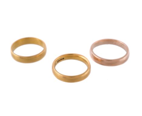 Two 22 carat gold band rings, finger size H 1/2 and K 1/2, 7.5g; and a further band ring, finger size M, 3.6g