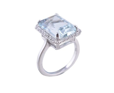 An aquamarine and diamond ring, the rectangular cut aquamarine claw set within a surround of brilliant cut diamonds, stamped 
