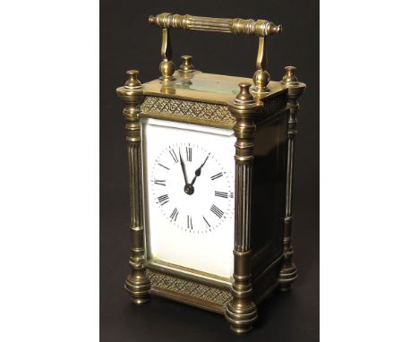 A Brass cased carriage clock with swing handle, five bevelled glass panels, the white unmarked enamel dial with Roman numeral