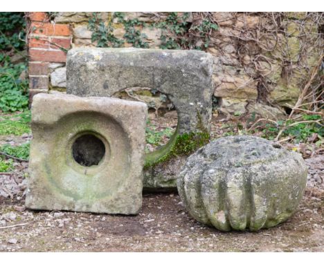 The lot comprising of a finial section, a plinth, and a drain cover.The finial 42cm x 34cm. The larger millng stone 55cm x 57