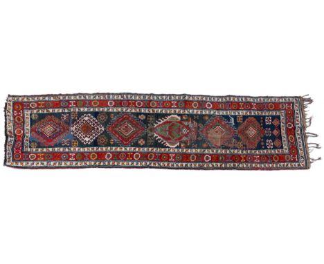 With a blue ground and six serrated medallions.379cm x 100cmQty: 1Significant wear to the pile throughout the rug, notable in