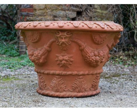 The terracotta planter decorated with foliate swags and masks.100cm diameter x 66cm highQty: 1Minor marks and chips. Weathere