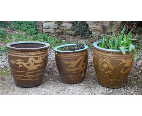 Each stoneware planter decorated with dragons and with glazed interiors.The largest 53cm diameter x 49cm highQty: 3The larger