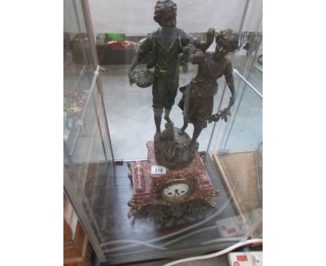 A French marble mantle clock surmounted a pair of figures