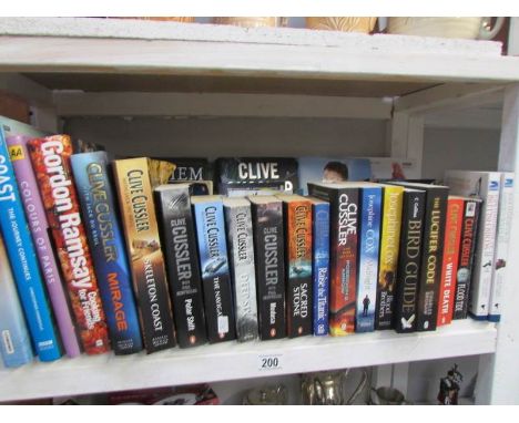 A shelf of books including Clive Cussler
