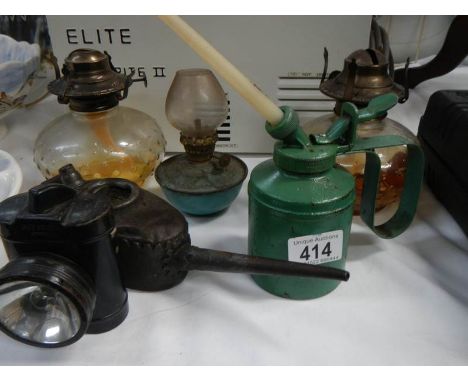A quantity of vintage oil cans and oil lamps