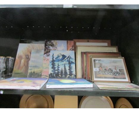 A shelf of assorted paintings and prints