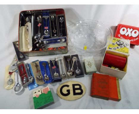 A mixed lot to include a large collection of crested teaspoons, a vintage GB car bumper badge, vintage playing cards and a pr