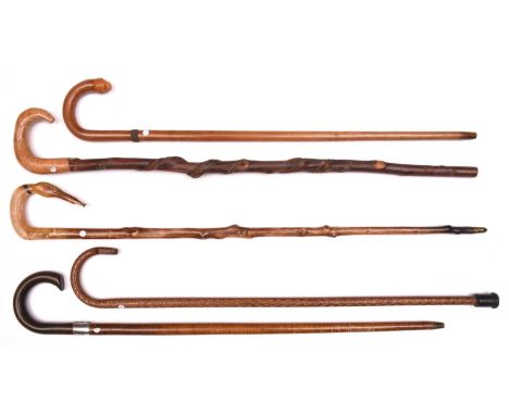5 walking sticks: pale wood with crook handle terminating in composition lion's head with glass eyes, and woven wire band, th