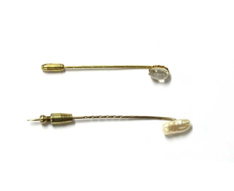 Two gold stick pins, one with a cabochon moonstone finial, claw set, to gold pin, tested as approximately 9ct gold, the other