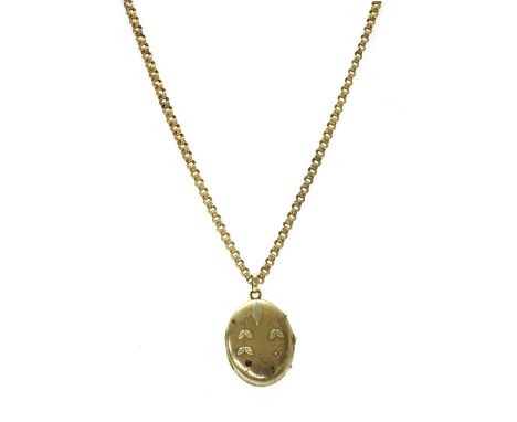 A Russian gold ruby set locket and chain, the oval locket set round mixed cut rubies, one deficient, and with applied green g
