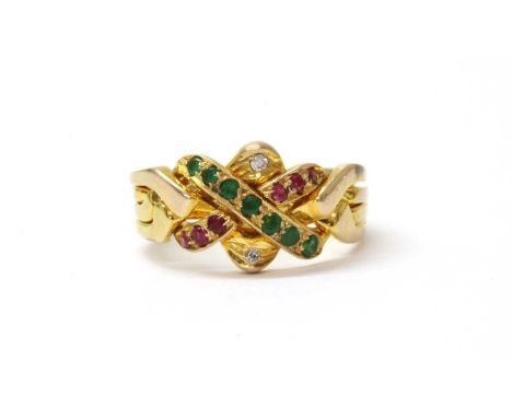 A gold emerald. ruby and diamond set puzzle ring, the four row puzzle ring grain set with round mixed cut emerald and rubies,