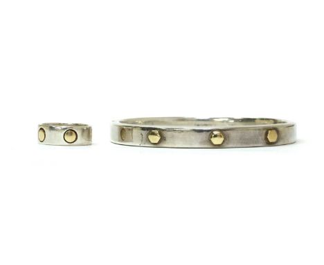 A sterling silver and gold bangle, the silver flat section hollow bangle with three applied gold hexagonal plates to the top 