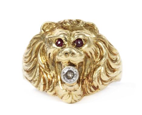 A gold lion head ring, the head of the ring in the form of a lion's head, with ruby set eyes and with a Swiss cut diamond rub