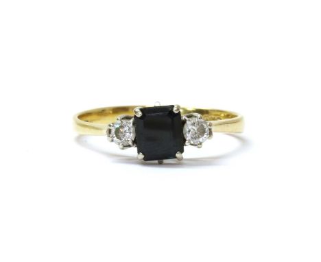 An 18ct gold sapphire and diamond three stone ring, with an emerald cut sapphire with a brilliant cut diamond at either side,