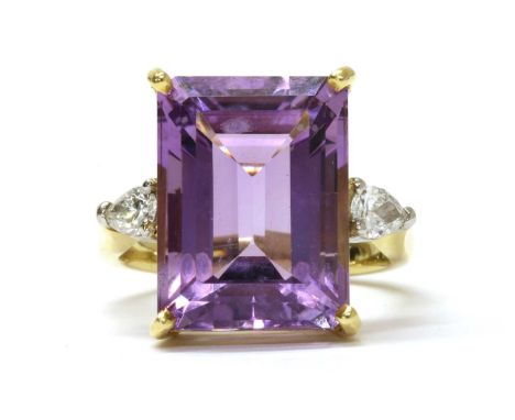 An 18ct gold amethyst and diamond three stone ring, with an emerald cut amethyst, approximately 16 x 12mm, with a pear brilli