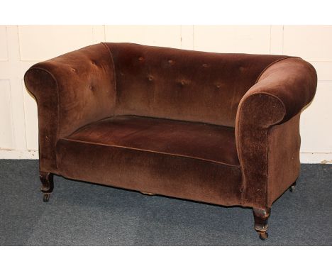 A small Chesterfield sofa with button back and brown upholstery, on short cabriole legs and castors, 138cm wide