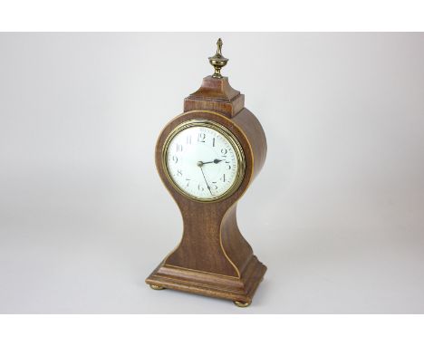 An Edwardian mahogany mantel clock with white enamel dial, in balloon shaped case with brass vase finial, 31cm