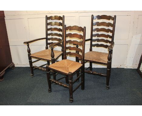 Two rush seated ladder back carver dining chairs and a matching single chair