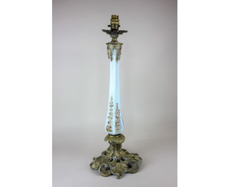 A brass mounted opaque glass table lamp with faceted stem on pierced scroll base, 53cm high