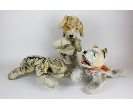 A Steiff tiger cub with metal button to ear, 40cm, and two dog character hand puppets, one with part paper label, 37cm