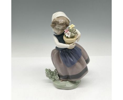 Figure of a young girl holding a pot of flowers with her clothes blowing in the wind. Glossy finish. Lladro backstamp. This i