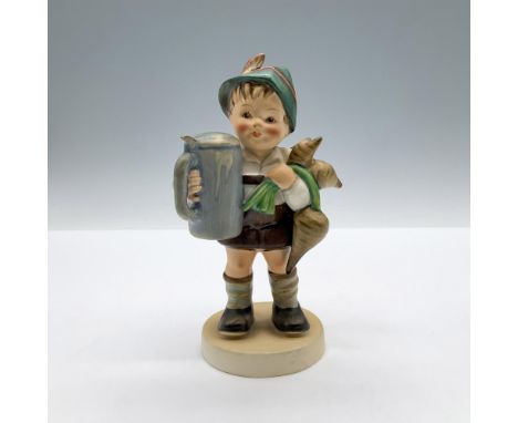 A matte hand painted figure of a boy dressed in traditional German attire, carrying a stein and a bouquet of radishes. Goebel