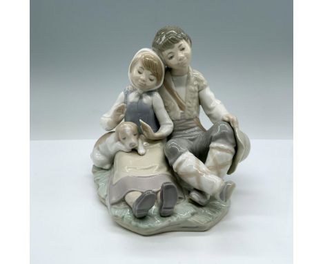 This glossy figurine depicts a boy and girl sitting together with a puppy dog. Lladro Daisa backstamp on the bottom. Artist: 