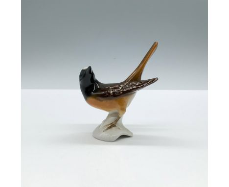 A glossy sculpture of an alert bird with black, brown, and gray coloration. Goebel backstamp. Dimensions: 3.25"L x 1.75"W x 4