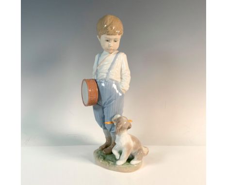 Glossy figure of a young boy with a drum. He is looking at the puppy with the drumsticks. Lladro backstamp. Artist: Regino To