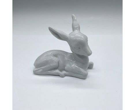 All white high glazed figure of a young deer resting. Wallendorf backstamp. Issued: 1960sDimensions: 4.75"L x 2.75"W x 4.25"H