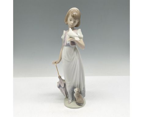 Handmade glazed figural girl leaning on umbrella, holding a dove with cat at base. Lladro backstamp. This item has its origin