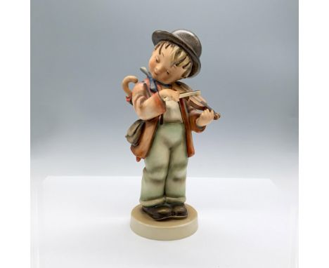 A matte hand painted sculpture of a young boy wearing a brown hat and blue scarf, carrying an umbrella on his back, as he pla