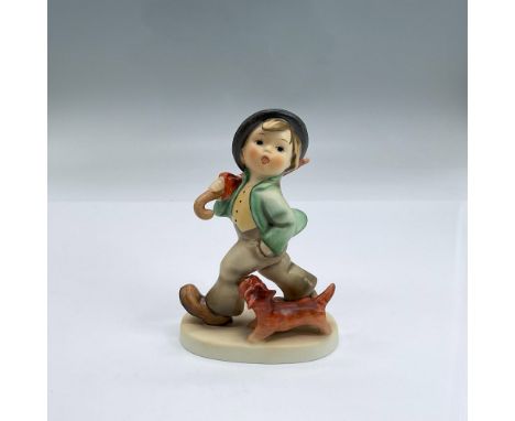 Hand painted figure of a boy mid-stride holding his umbrella in one hand and the other in his pocket. His little terrier walk