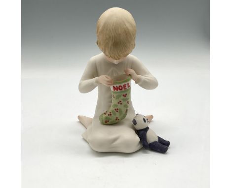 Handmade, hand painted bisque porcelain of young boy looking into his Christmas stocking with his panda bear nearby. Cybis ba