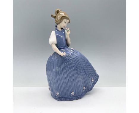 Beautiful glossy figurine of young girl in a blue dress with rippled skirt adorned with tiny delicate flowers. Lladro backsta