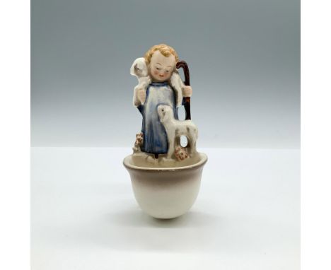 A semi-glossy wall sculpture of a boy holding a cane and carrying a lamb over his shoulders while another lamb stands by, wit