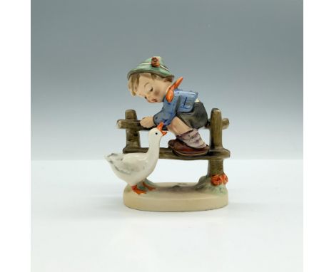 A matte hand painted figure of a boy on a fence, looking down at a duck who is quacking at him. Goebel backstamp. M.I. Hummel