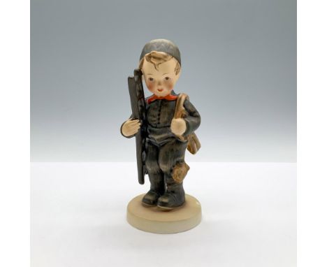 A matte hand painted figure of a boy wearing a black uniform and hat, carrying a ladder and rope. Goebel backstamp. M.I. Humm