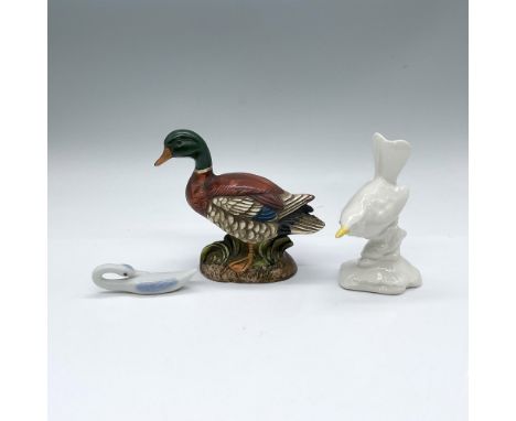 A collection of bird figures from various locations. Includes a porcelain white and blue swan from Japan, a porcelain white s