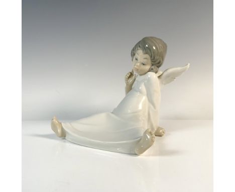 Glazed figurine of a seated angel. Lladro backstamp. Artist: Salvador DebonIssued: 1977-2017Dimensions: 6.5"L x 6"W x 5.5"HMa