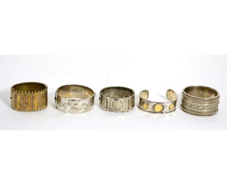 A Victorian silver hinge opening bangle with engraved and beaded detail, two other Victorian bangles, a modern silver example
