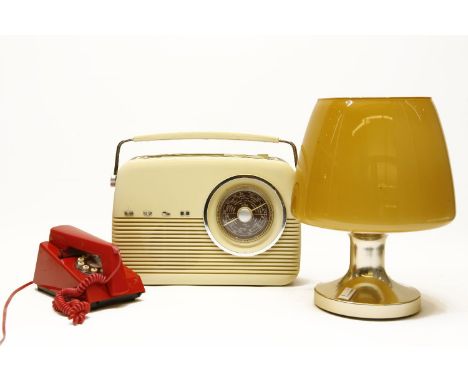 A retro Bush radio, a retro red telephone and a yellow vintage style lamp