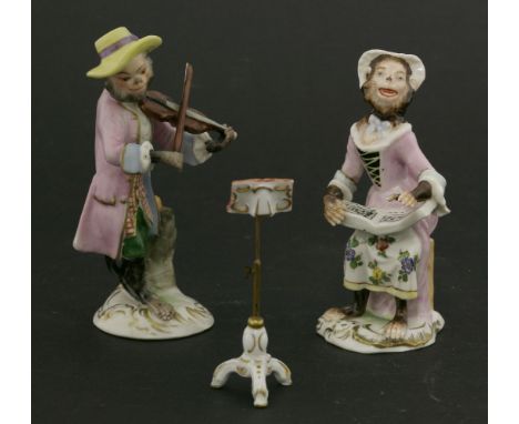 A pair of monkey musicians,one playing a violin, the other singing,plus a music stand,11, 10 and 7cm high (3) 