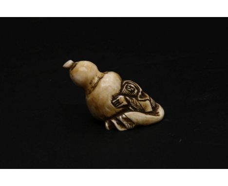 A Japanese ivory netsuke, of a man holding a large gourd, 5.25cm long