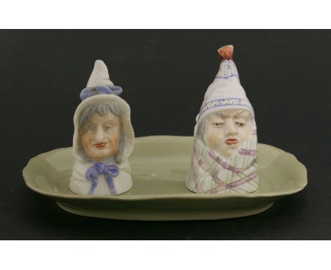 A Worcester porcelain snuffer of an old man wrapped in a blanket, together with a similar snuffer in the form of an old lady,