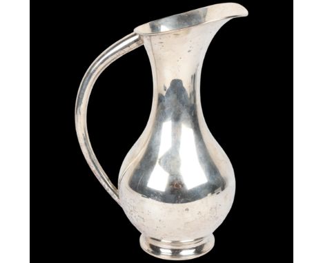 A large Japanese silver ewer, circa 1940, signed on base, baluster form with large tapered handle and flared rim, 28cm, 19.9o