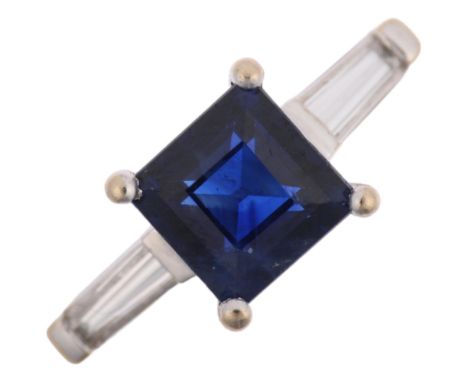 A modern 18ct white gold three stone sapphire and diamond ring, claw set with 1ct square step-cut sapphire flanked by tapered