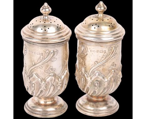 A pair of Art Nouveau Edwardian silver pedestal pepperettes, Henry Matthews, Birmingham 1904, relief embossed half fluted dec