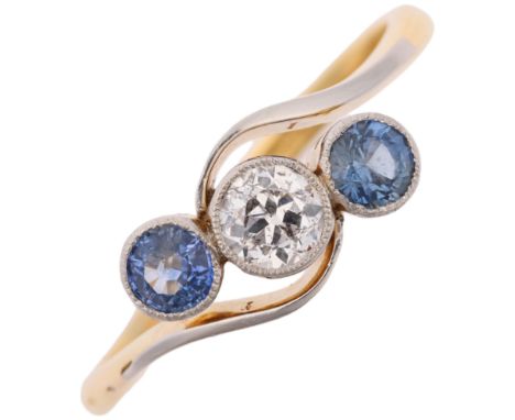 An early 20th century 18ct gold three stone sapphire and diamond crossover ring, platinum-topped set with round-cut sapphires